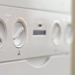 Close-up view of the dials and controls on a white household appliance, likely a washing machine or dryer—ideal for homes undergoing bathroom refurbishments or central heating installations, highlighting the settings panel and dial indicators.
